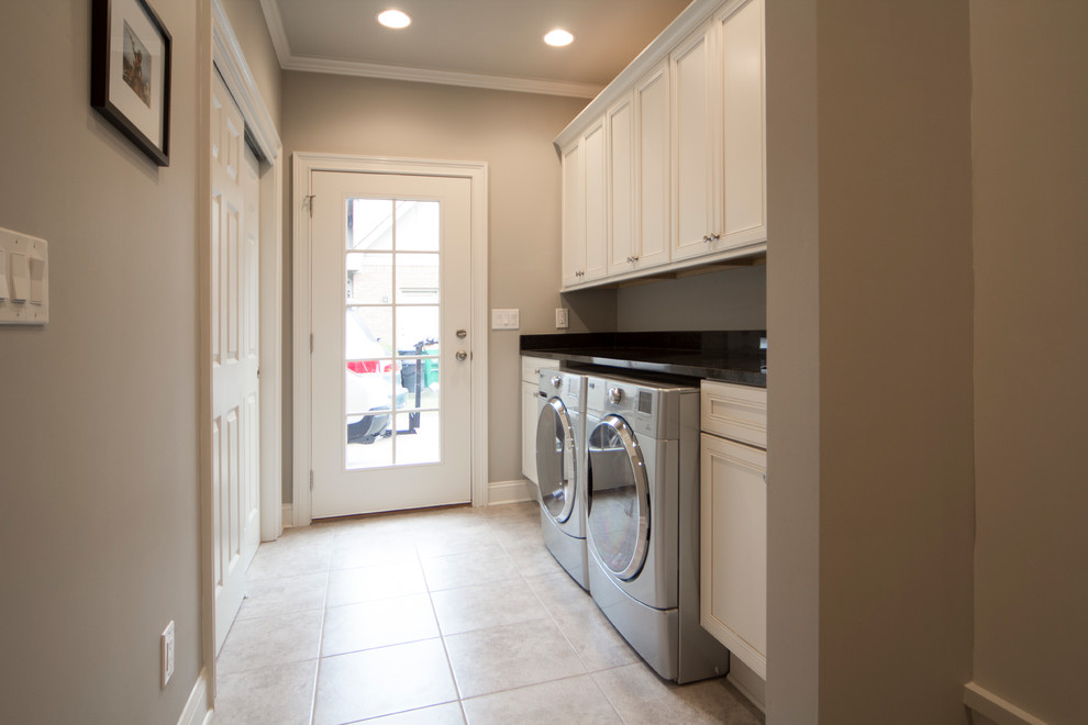 This is an example of a mid-sized transitional dedicated laundry room in Atlanta with white cabinets, beige walls and a side-by-side washer and dryer.
