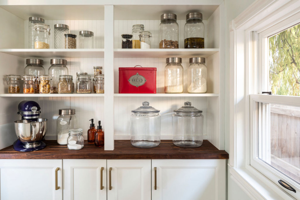 Inspiration for a small eclectic l-shaped utility room in Denver with shaker cabinets, white cabinets, wood benchtops, white splashback, shiplap splashback, blue walls, medium hardwood floors, a side-by-side washer and dryer, brown floor, brown benchtop and planked wall panelling.