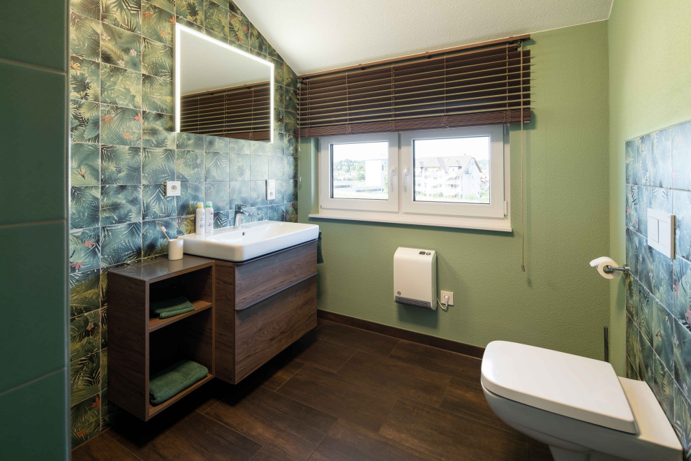 Small rustic cloakroom in Other with brown cabinets, a wall mounted toilet, green tiles, green walls, wood-effect flooring, a vessel sink, wooden worktops and brown floors.
