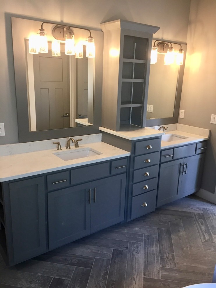 Photo of a mid-sized arts and crafts master wet room bathroom in Kansas City with shaker cabinets, grey cabinets, a freestanding tub, a two-piece toilet, white tile, porcelain tile, grey walls, ceramic floors, an undermount sink, engineered quartz benchtops, grey floor and a hinged shower door.