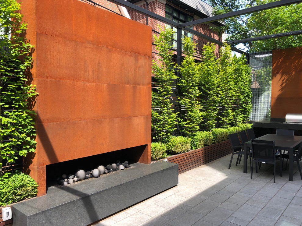 Exemple d'un jardin sur toit moderne de taille moyenne et l'été avec une cheminée, une exposition partiellement ombragée et une clôture en bois.