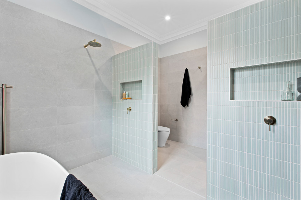 Large beach style master wet room bathroom in Sydney with flat-panel cabinets, light wood cabinets, a freestanding tub, a two-piece toilet, blue tile, gray tile, an undermount sink, an open shower, a niche, a single vanity and a floating vanity.
