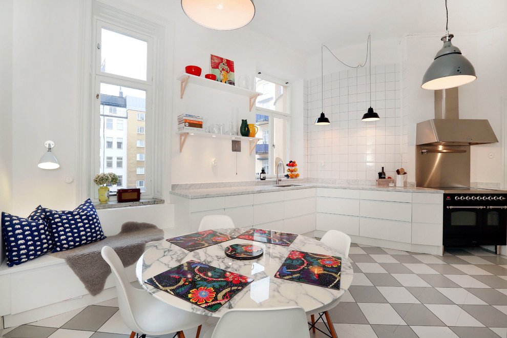 Design ideas for a small eclectic single-wall eat-in kitchen in Stockholm with flat-panel cabinets, white cabinets, marble benchtops, white splashback, ceramic splashback, black appliances, ceramic floors and no island.