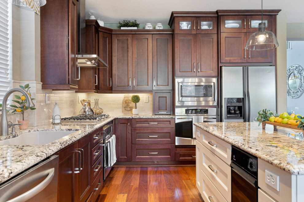 Open concept kitchen - mid-sized transitional l-shaped medium tone wood floor and brown floor open concept kitchen idea in San Francisco with an undermount sink, recessed-panel cabinets, dark wood cabinets, granite countertops, beige backsplash, marble backsplash, stainless steel appliances, an island and beige countertops