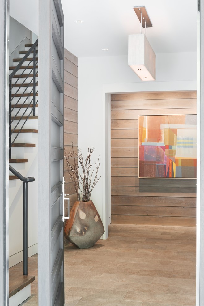 This is an example of a contemporary entryway in Other with white walls and terra-cotta floors.