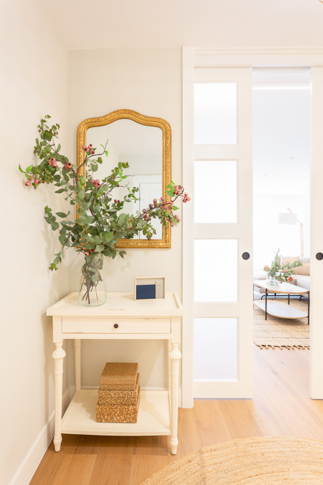 This is an example of a mid-sized transitional entry hall in Madrid with beige walls, ceramic floors, a sliding front door and a white front door.