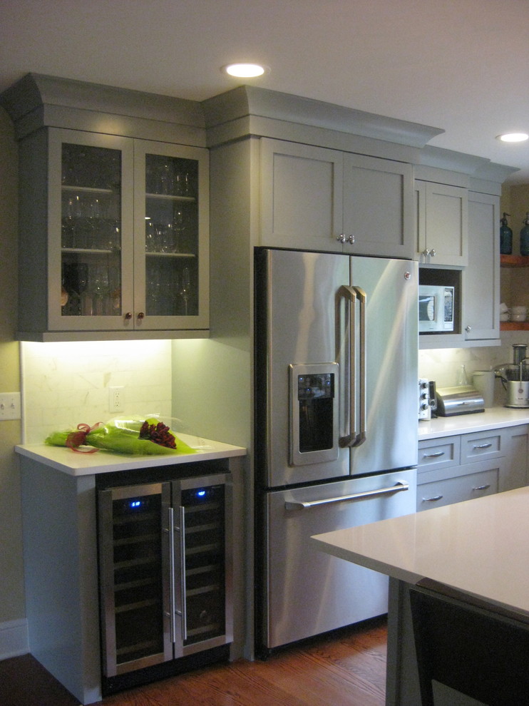 This is an example of a mid-sized transitional u-shaped eat-in kitchen in New York with an undermount sink, shaker cabinets, green cabinets, quartz benchtops, multi-coloured splashback, marble splashback, stainless steel appliances, medium hardwood floors, with island, red floor and white benchtop.
