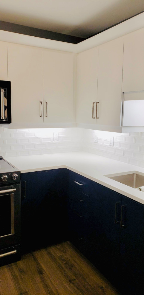 Inspiration for a transitional u-shaped open concept kitchen remodel with an undermount sink, flat-panel cabinets, white cabinets, quartzite countertops, white backsplash, porcelain backsplash, no island and white countertops