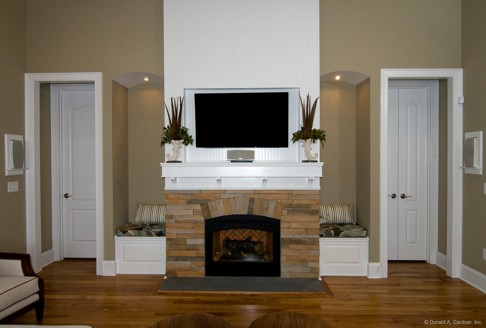 Photo of a mid-sized arts and crafts open concept living room in Wilmington with beige walls, medium hardwood floors, a standard fireplace, a stone fireplace surround and a built-in media wall.