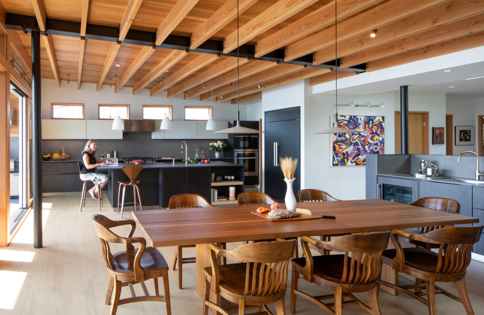 Exemple d'une salle à manger ouverte sur la cuisine moderne avec un sol jaune et un plafond en bois.
