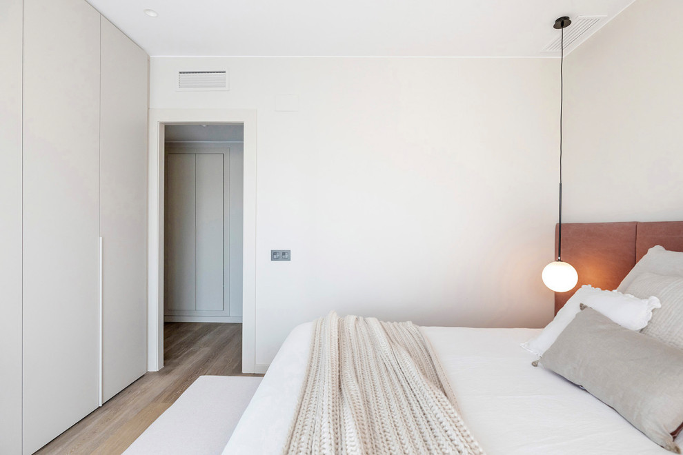 Diseño de dormitorio principal actual de tamaño medio con paredes beige, suelo de madera en tonos medios y suelo beige