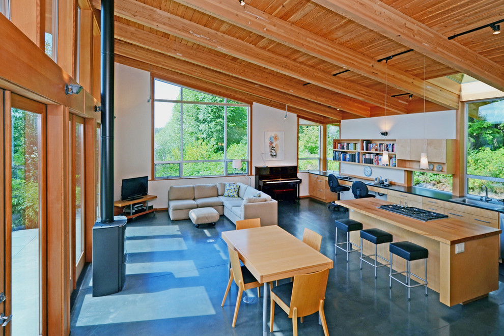This is an example of a contemporary living room in Seattle with concrete floors and a wood stove.