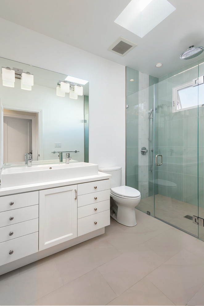 Design ideas for a contemporary bathroom in San Francisco with a trough sink, shaker cabinets, white cabinets, a curbless shower, a two-piece toilet, blue tile and white walls.