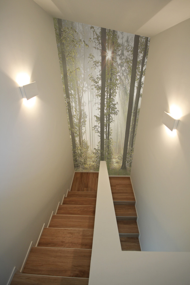 На фото: большая прямая лестница в стиле модернизм с деревянными ступенями, крашенными деревянными подступенками и обоями на стенах с