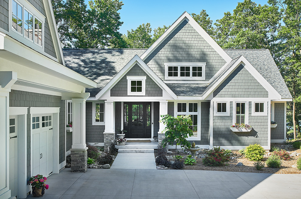 Inspiration for a contemporary grey house exterior in Grand Rapids with mixed siding, a gable roof and a shingle roof.
