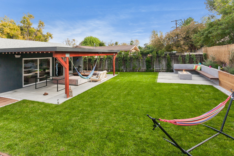 Large transitional backyard deck in Los Angeles with an outdoor shower and a roof extension.
