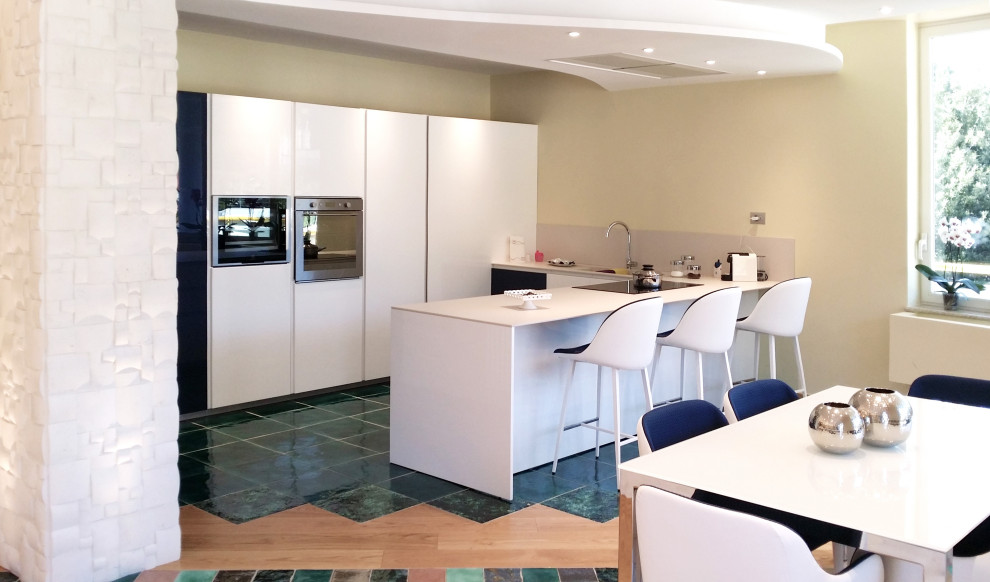 他の地域にある中くらいなトラディショナルスタイルのおしゃれなキッチン (白いキャビネット、クオーツストーンカウンター、セラミックタイルの床、緑の床、白いキッチンカウンター) の写真