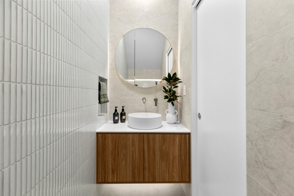 Small contemporary master bathroom in Sydney with furniture-like cabinets, medium wood cabinets, a one-piece toilet, multi-coloured tile, porcelain tile, multi-coloured walls, porcelain floors, a vessel sink, solid surface benchtops, multi-coloured floor, white benchtops, a niche, a single vanity and a floating vanity.
