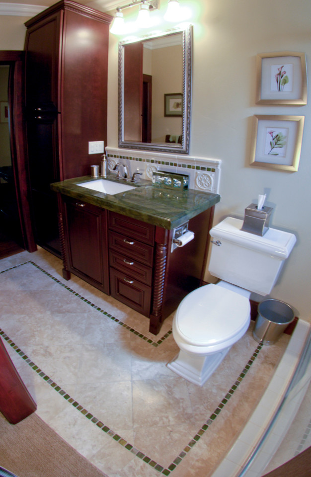 Photo of a mid-sized mediterranean 3/4 bathroom in Los Angeles with furniture-like cabinets, brown cabinets, an alcove shower, a two-piece toilet, white tile, ceramic tile, beige walls, travertine floors, an undermount sink and granite benchtops.
