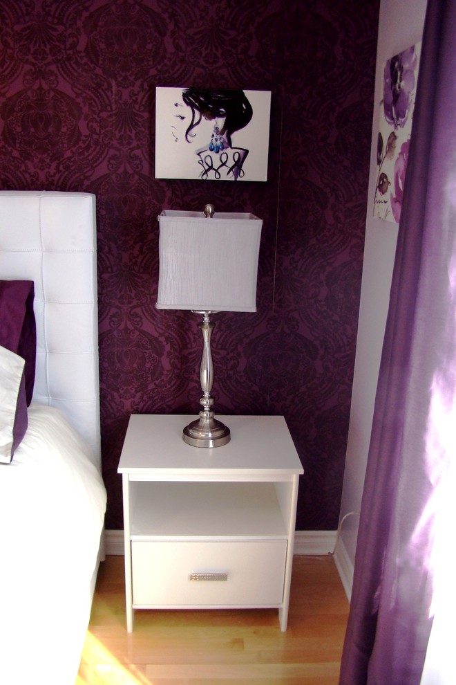 Photo of a mid-sized transitional bedroom in Montreal with purple walls, light hardwood floors, brown floor and wallpaper.