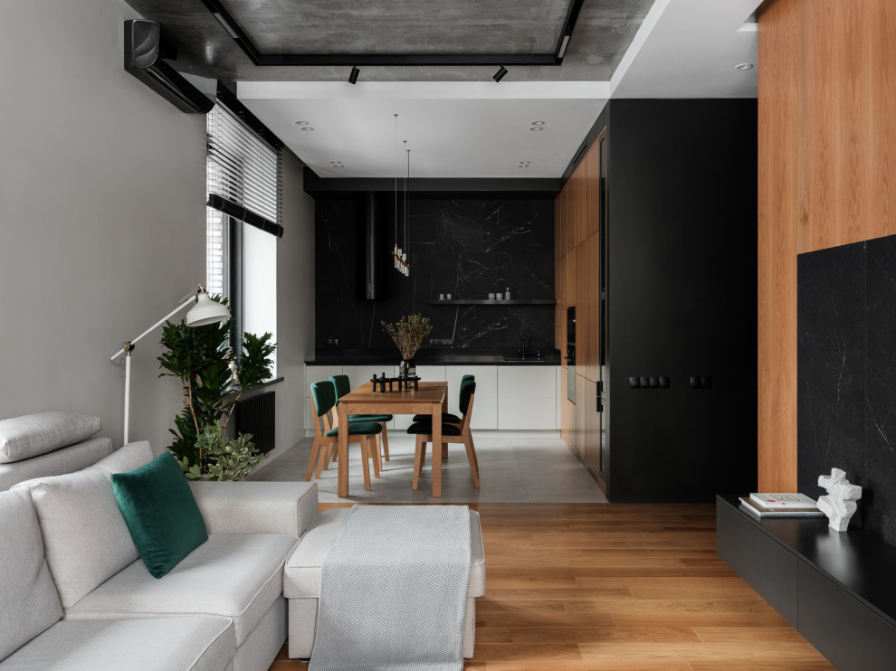 This is an example of a large contemporary open plan living room in Saint Petersburg with a music area, black walls, medium hardwood flooring, a wall mounted tv, brown floors and panelled walls.