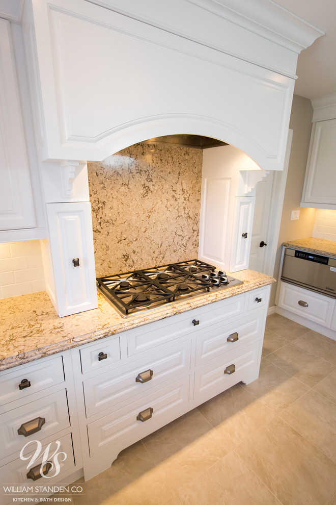 Eat-in kitchen - mid-sized transitional u-shaped porcelain tile eat-in kitchen idea in Toronto with an undermount sink, raised-panel cabinets, white cabinets, quartzite countertops, beige backsplash, stone slab backsplash, stainless steel appliances and an island