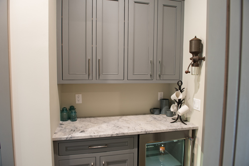 Small transitional single-wall wet bar in Charleston with no sink, beaded inset cabinets, grey cabinets, quartzite benchtops, dark hardwood floors and brown floor.