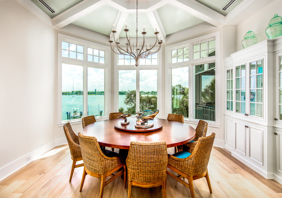 Mid-sized beach style open plan dining in Tampa with light hardwood floors, brown floor and white walls.