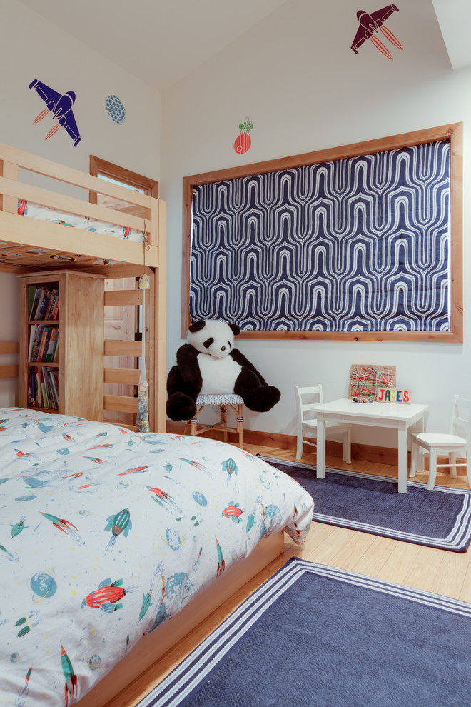 Photo of a mid-sized eclectic kids' bedroom for kids 4-10 years old and boys in Denver with white walls and bamboo floors.