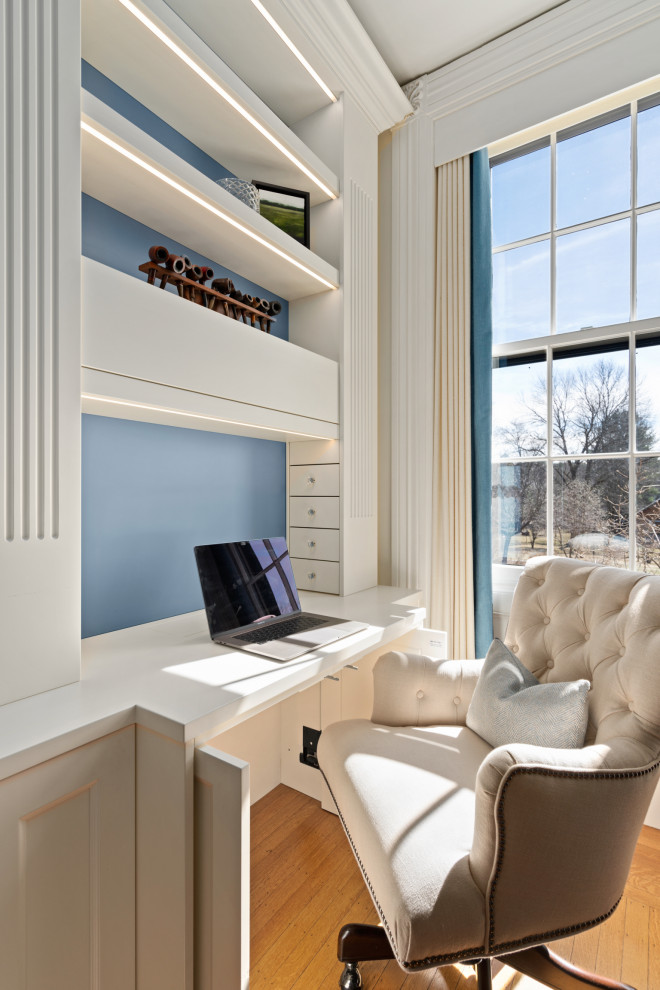 Großes Landhausstil Lesezimmer mit weißer Wandfarbe, braunem Holzboden, Kamin, Kaminumrandung aus Stein, Einbau-Schreibtisch und braunem Boden in Boston
