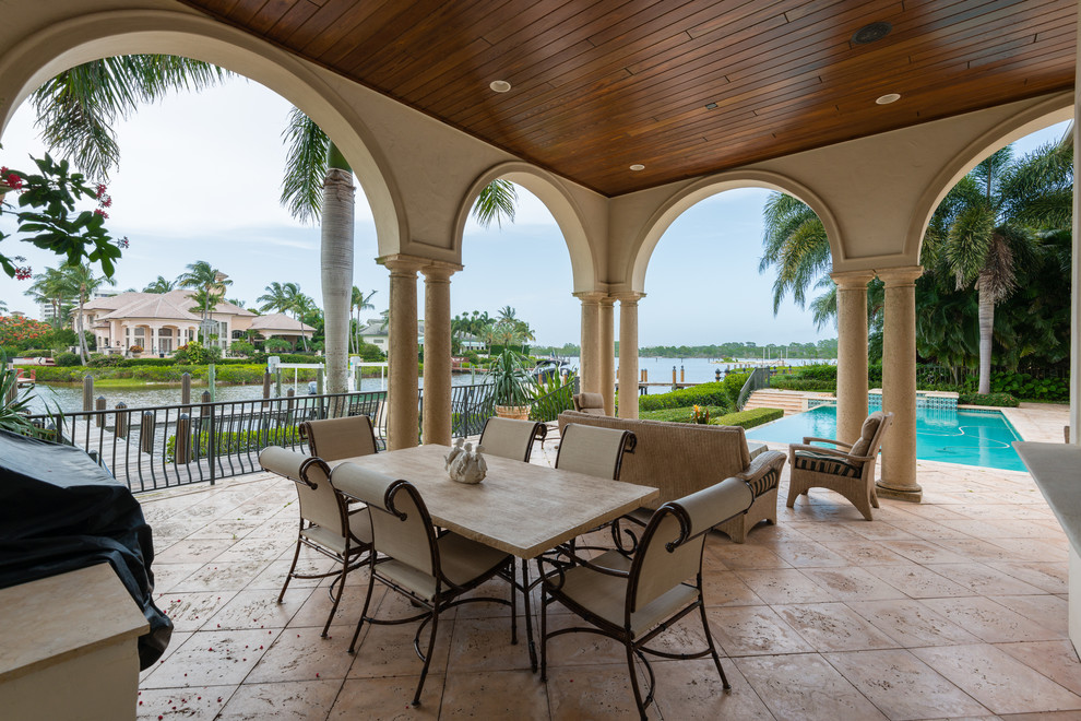 Inspiration for a traditional patio in Miami with a roof extension.