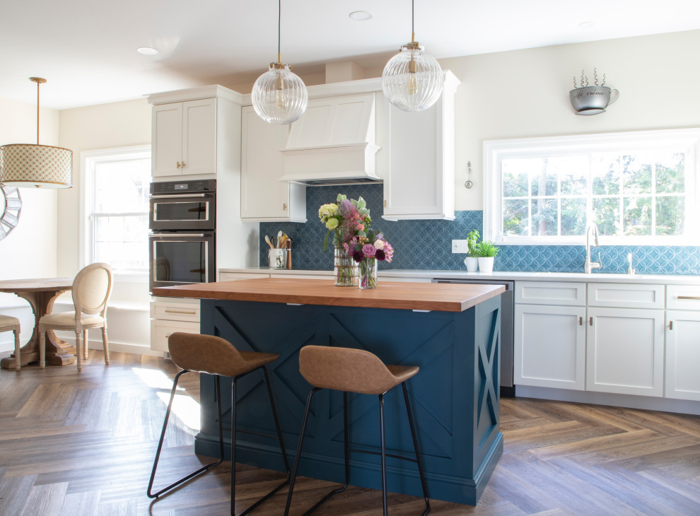 Inspiration for a transitional kitchen in Other with an undermount sink, shaker cabinets, blue cabinets, wood benchtops, blue splashback, ceramic splashback, black appliances, vinyl floors, with island and brown benchtop.