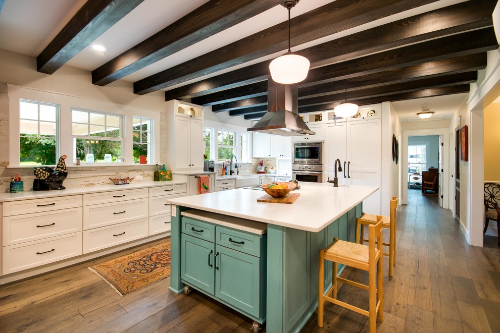 Cottage l-shaped medium tone wood floor kitchen photo in Other with a farmhouse sink, shaker cabinets, white cabinets, marble countertops, multicolored backsplash, stainless steel appliances and two islands