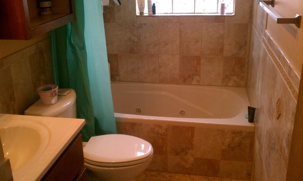 This is an example of a mid-sized traditional kids bathroom in Chicago with a drop-in tub, a shower/bathtub combo, a one-piece toilet, beige tile, ceramic tile, beige walls and ceramic floors.