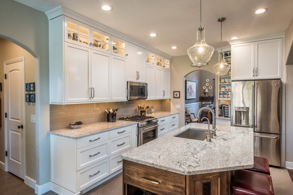 Photo of a mid-sized transitional l-shaped eat-in kitchen in Other with shaker cabinets, white cabinets and with island.