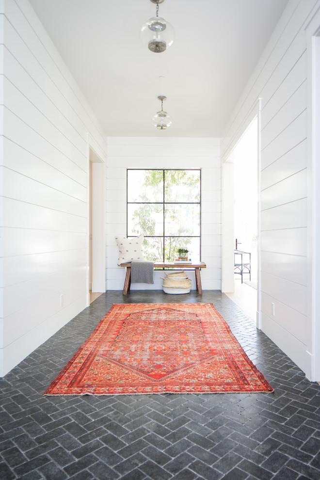 Transitional entry hall in Orange County with white walls, brick floors and grey floor.