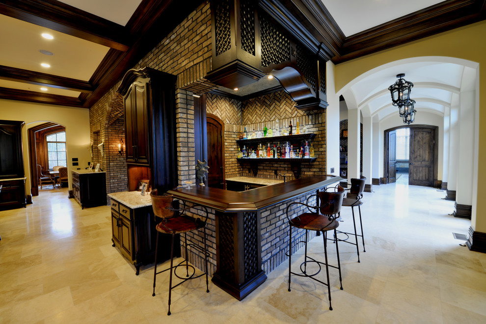Mid-sized mediterranean u-shaped seated home bar in Indianapolis with wood benchtops, brown splashback, brick splashback, travertine floors and brown benchtop.