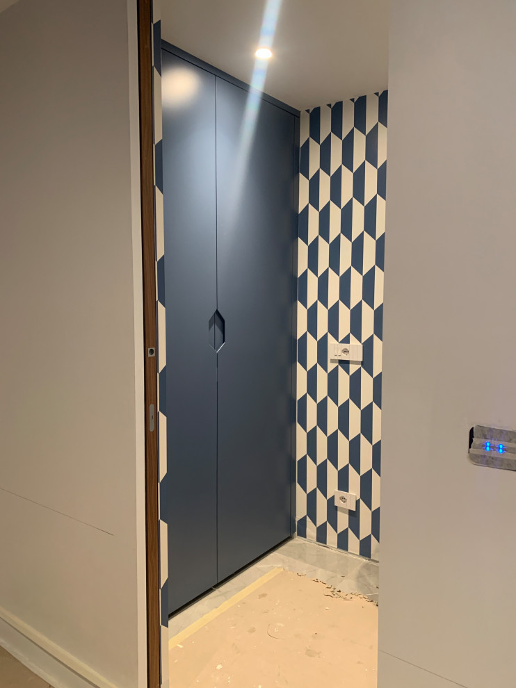 Modern inredning av en liten foajé, med laminatgolv, en dubbeldörr, en blå dörr och grått golv