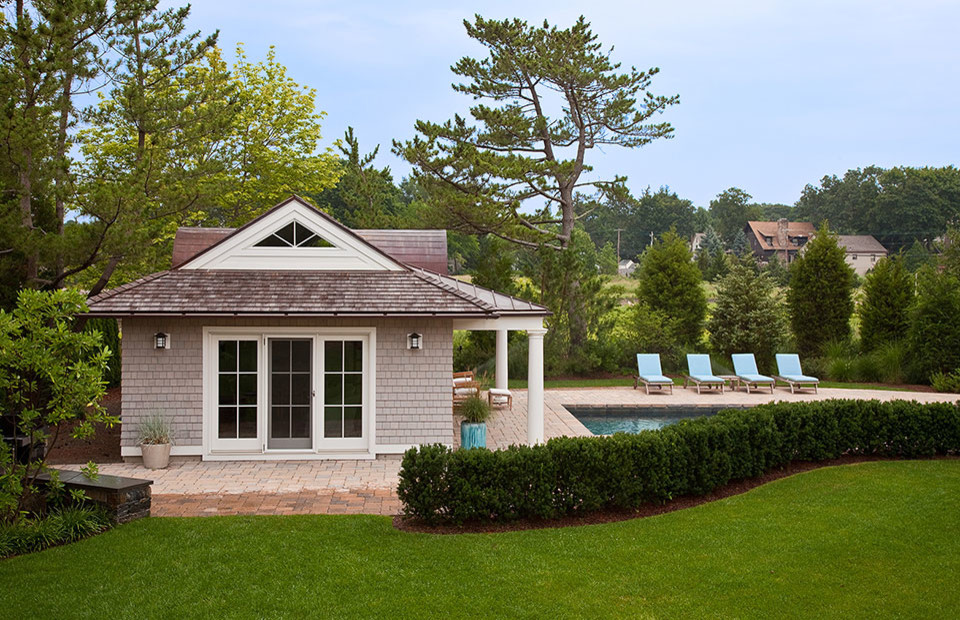 Photo of a small traditional backyard rectangular lap pool in New York with a pool house and concrete pavers.