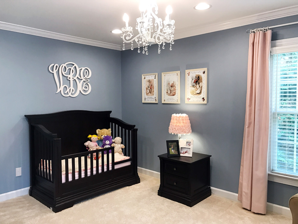 This is an example of a transitional nursery for girls in Raleigh with blue walls and beige floor.