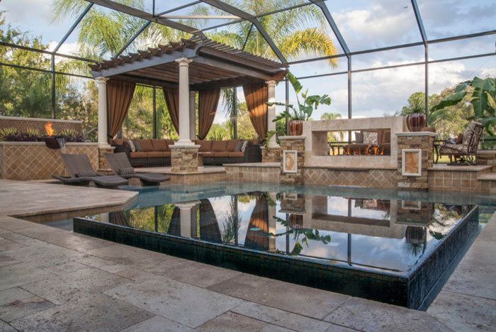 Photo of a small transitional custom-shaped infinity pool in Tampa with natural stone pavers.