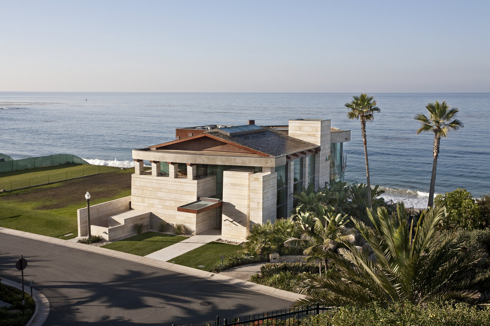 Large contemporary three-storey house exterior in Orange County with stone veneer and a gable roof.