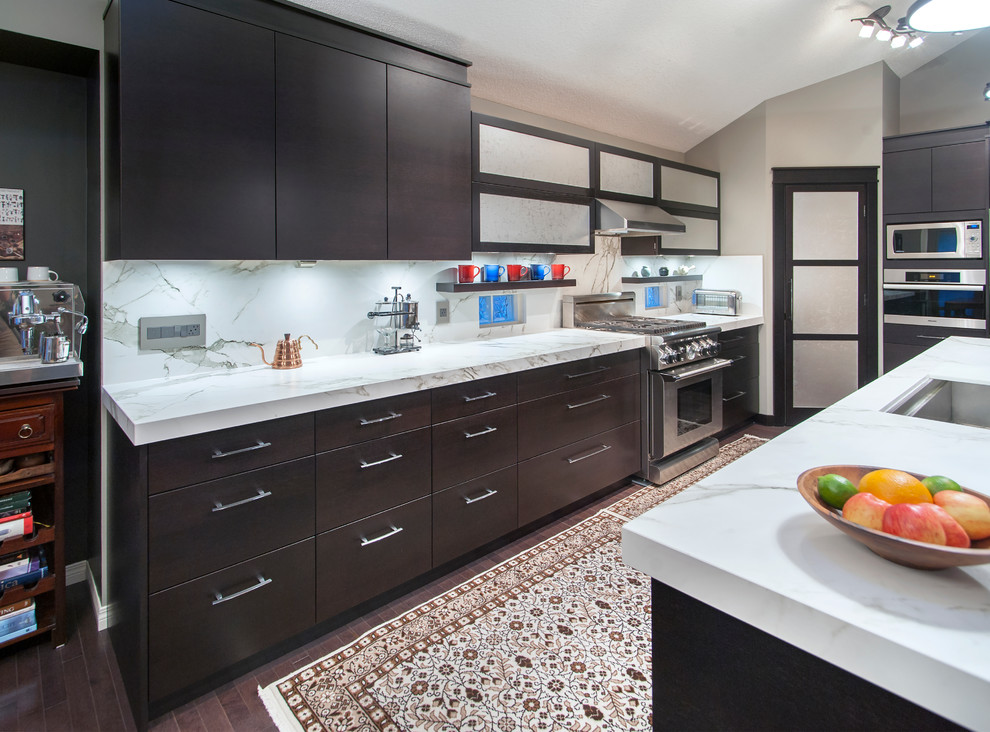 Photo of a contemporary l-shaped open plan kitchen in Calgary with an undermount sink, flat-panel cabinets, dark wood cabinets, marble benchtops, white splashback, stone slab splashback, stainless steel appliances and with island.