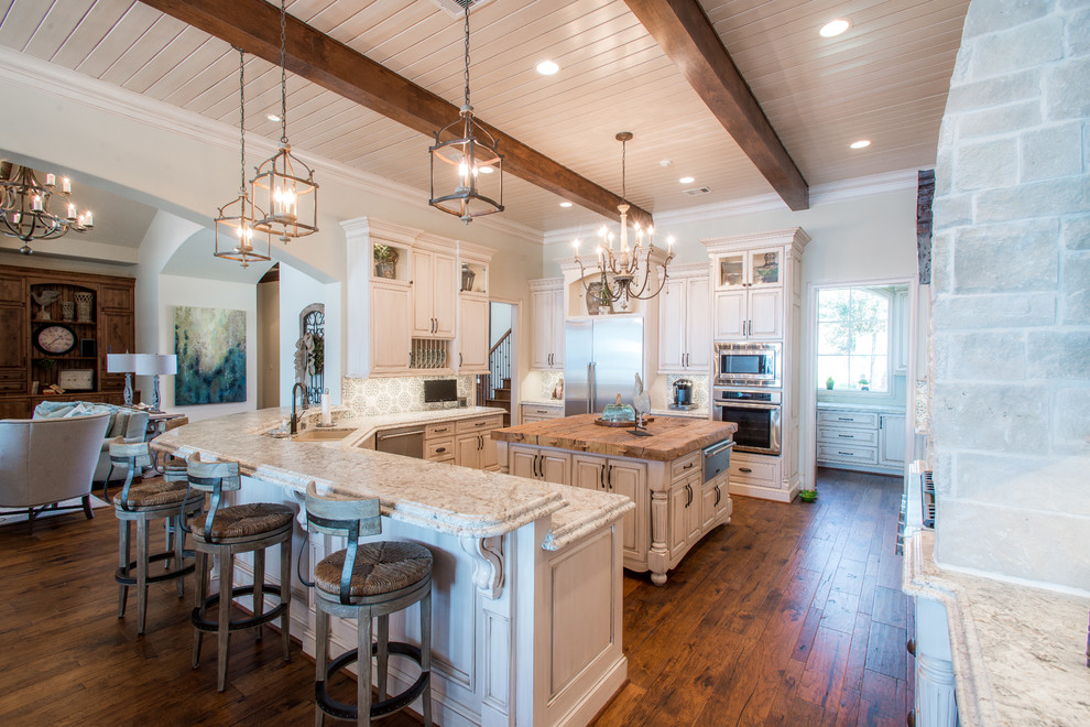 This is an example of a large traditional u-shaped open plan kitchen in Houston with an undermount sink, raised-panel cabinets, white cabinets, granite benchtops, blue splashback, stainless steel appliances, medium hardwood floors and with island.
