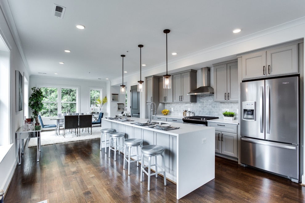 Inspiration for a mid-sized transitional galley open plan kitchen in DC Metro with an undermount sink, recessed-panel cabinets, grey cabinets, grey splashback, stainless steel appliances, dark hardwood floors, with island, brown floor, white benchtop, quartz benchtops and marble splashback.