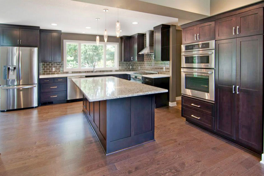 Example of a large transitional l-shaped dark wood floor and brown floor eat-in kitchen design in Orange County with an undermount sink, shaker cabinets, subway tile backsplash, stainless steel appliances, an island, dark wood cabinets, granite countertops and brown backsplash