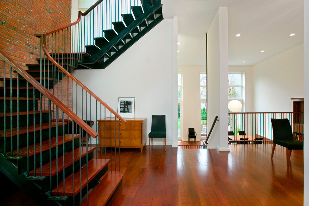 Design ideas for a contemporary entryway in New York with white walls and red floor.