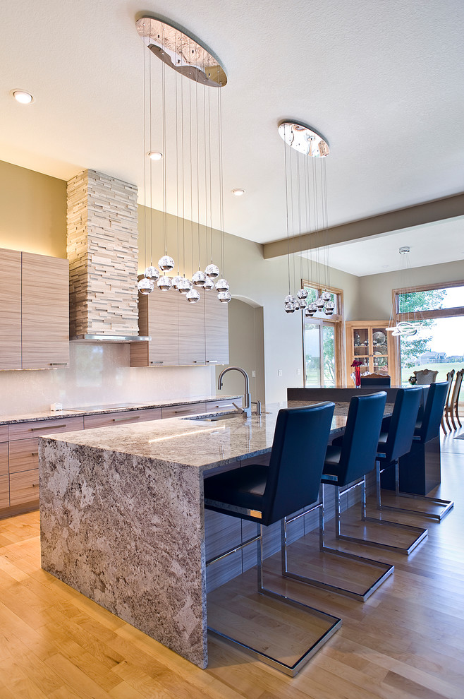 Inspiration for a mid-sized transitional l-shaped light wood floor and yellow floor open concept kitchen remodel with an undermount sink, flat-panel cabinets, light wood cabinets, granite countertops, beige backsplash, stone slab backsplash, paneled appliances and an island