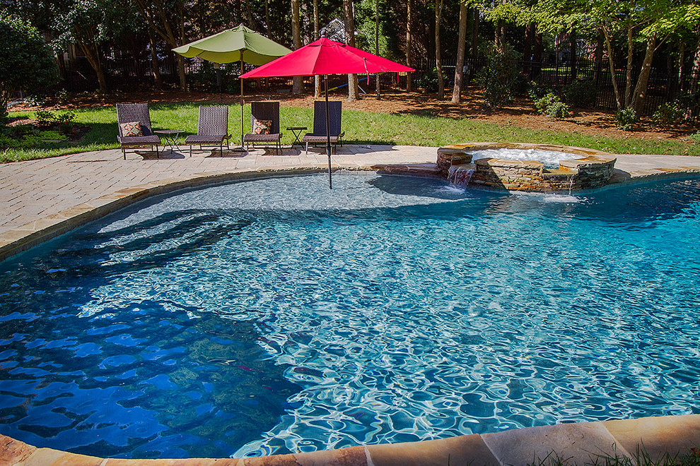 Example of a large mountain style backyard concrete paver and custom-shaped natural hot tub design in Raleigh