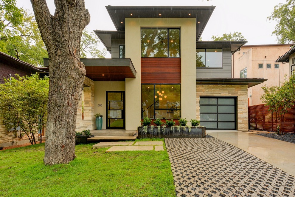 Photo of a contemporary two-storey beige exterior in Austin with mixed siding and a flat roof.